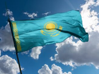 The flag of Kazakhstan mounted on a pole, fluttering in the wind.
